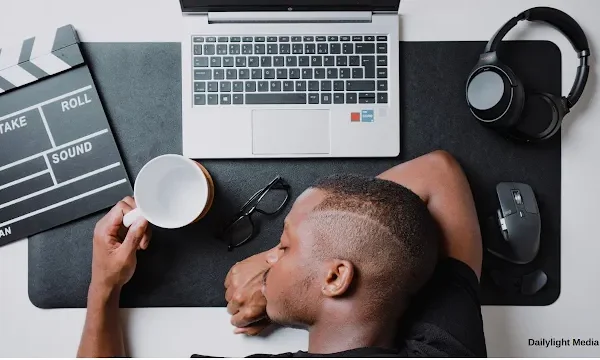 A young boy with his head placed on the table suffering from proscratination