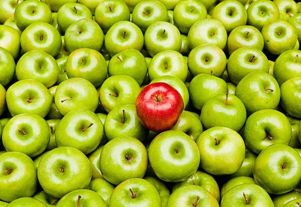 A red apple amidst many green apples indicating how to overcome inconsistency